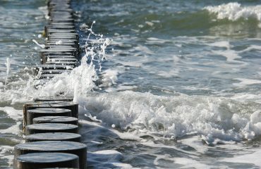 sea waves breaking against a wave barrier