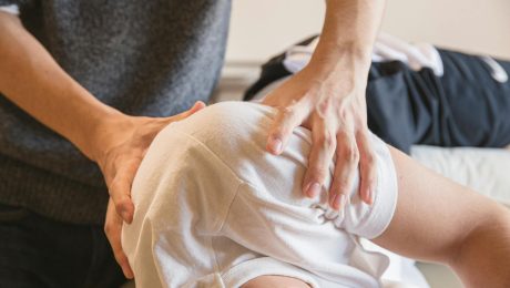 male doctor massaging shoulders of patient