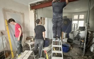 Builders installing a steel beam in Folkestone