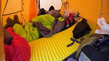 Die Luftmatratze. Unaufgeräumtes Zelt mit gelber Luftmatratze.