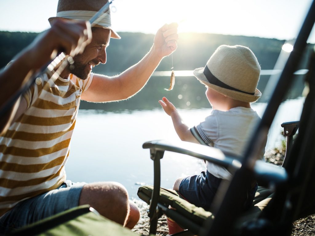 Tipps für das Angeln. Ein Vater fischt mit seinem kleinen Sohn an einem See.