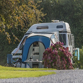 Ein Caravan mit Vorzelt steht auf einem Zeltplatz.