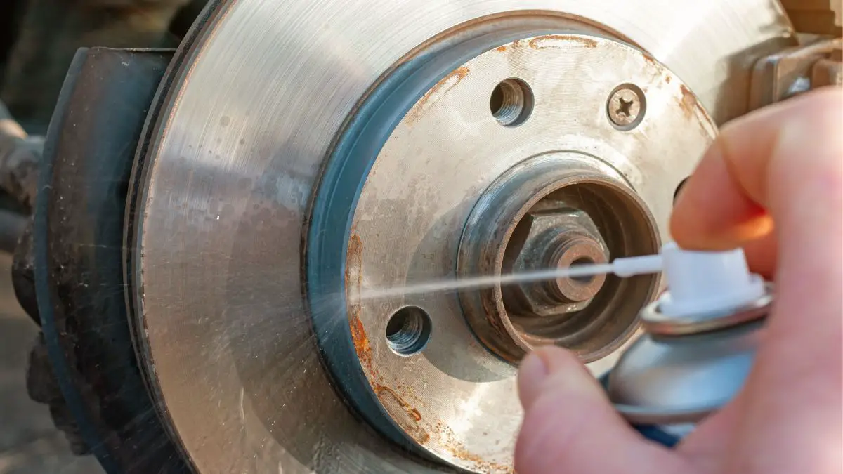 spraying brake cleaner on brake rotor