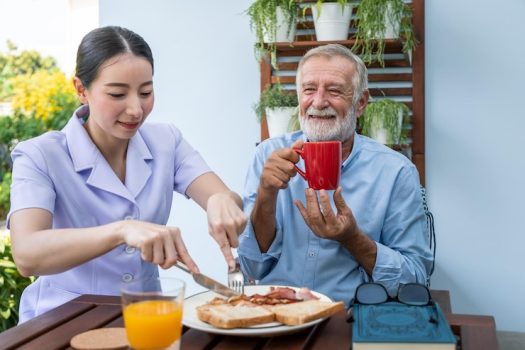 nurse-assist-elderly-senior-man-eat-breakfast-drink-coffee-with-mug-hand-nursing-home_554837-199