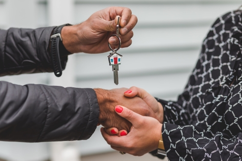 Real estate agent handing over the keys to a new home to their client.