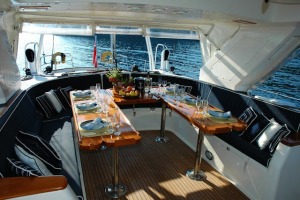 A well-set dining table on a yacht with a view of the open sea, showcasing luxury dining at sea.
