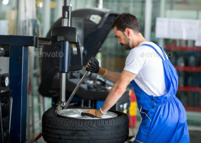 mechanic replace tires on wheels