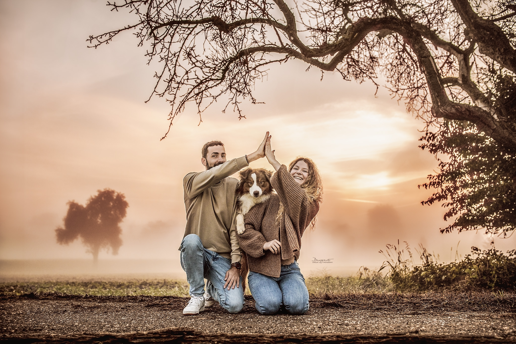 Junges Paar mit Hund bei Sonnenaufgang