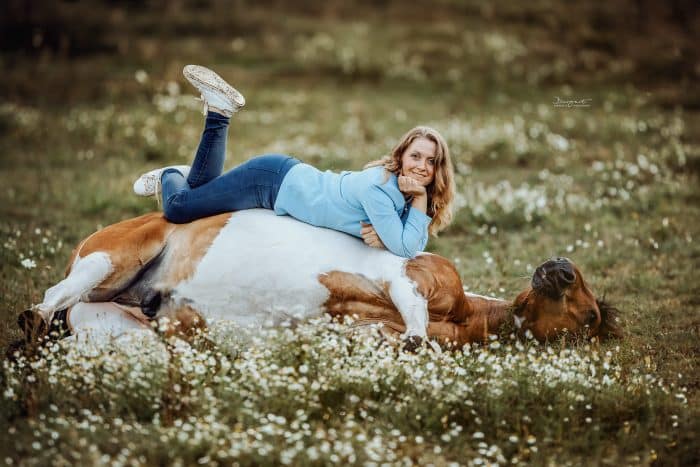 Frau liegt auf Pferd