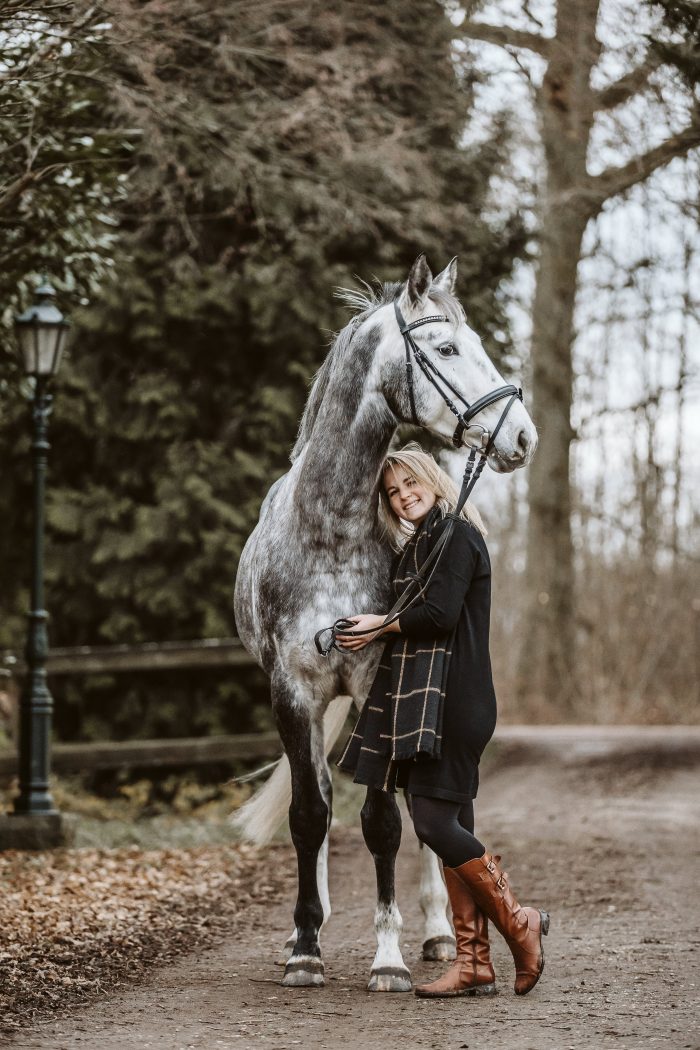 Junge Frau mit Pferd beim Wintershooting