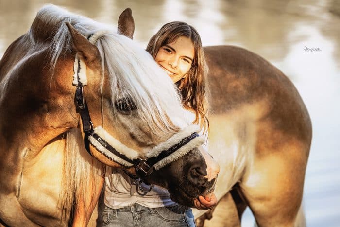 junge Frau mit ihrem Haflinger am See