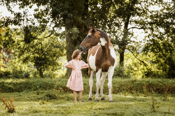 Mädchen mit Pferd auf der Koppel