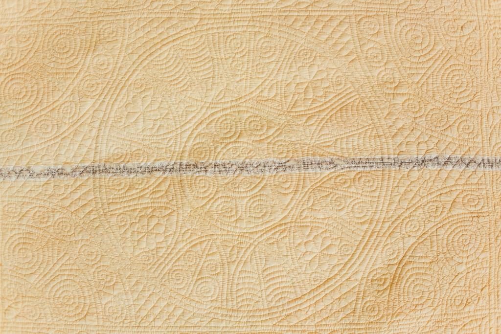 Quilted fan motifs around the centre circle.