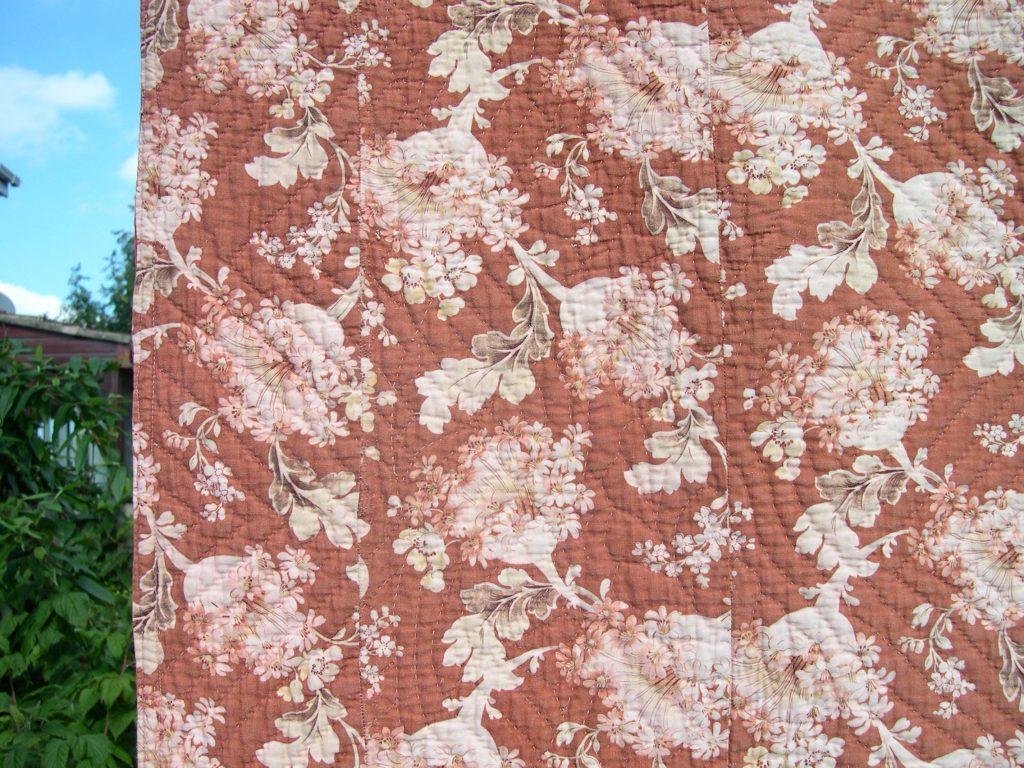 Narrow strip of floral fabric stitched onto the edge of the quilt back