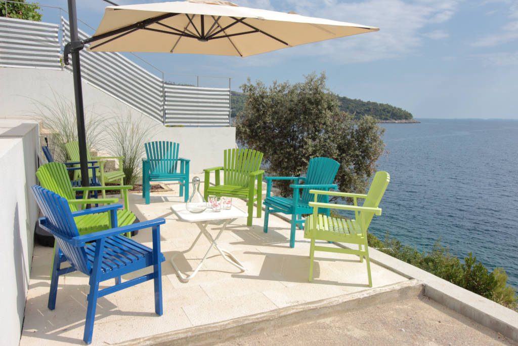 Lower lounge, colorful chairs, natural stone floor, sunbrella, sea view