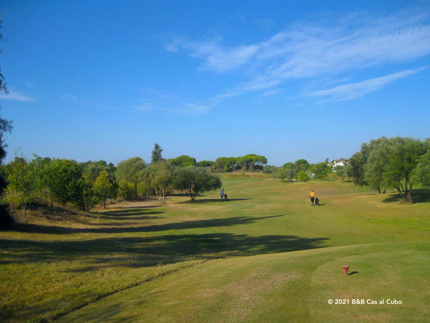De green met golfers bij Benamor Golfbaan