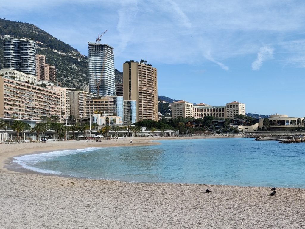 A manmade beach next to a row of high rise buildings and city landscape