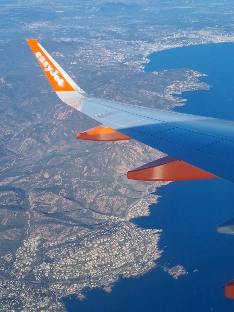 Image from a window of a plan looking down at the land and sea below