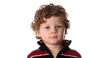 Young child looking serious on a white background