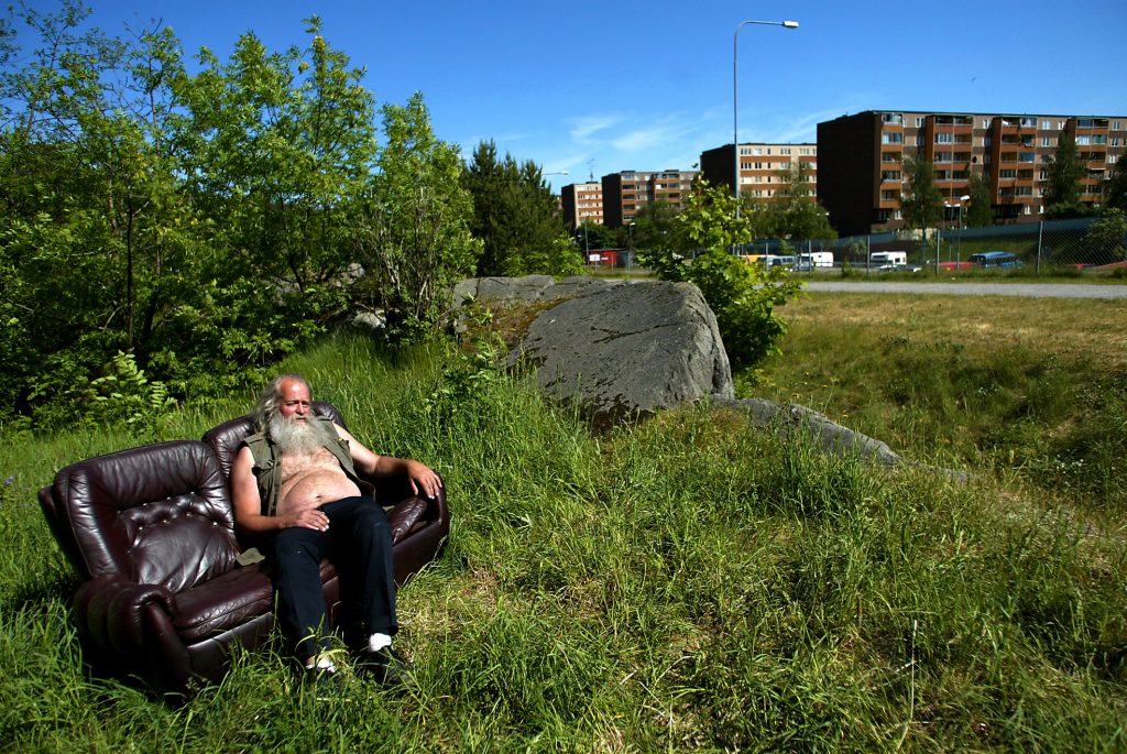 Soffan i brunt skinn är ett av Örjans alla fynd från containrar i Fisksätra. Örjan har ställt den i gröngräset, ett stenkast från sin husvagn på lastbilsparkeringen.