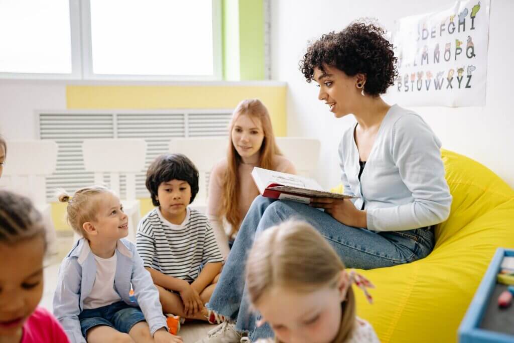 Kindergruppe hört Erzieherin beim Vorlesen zu