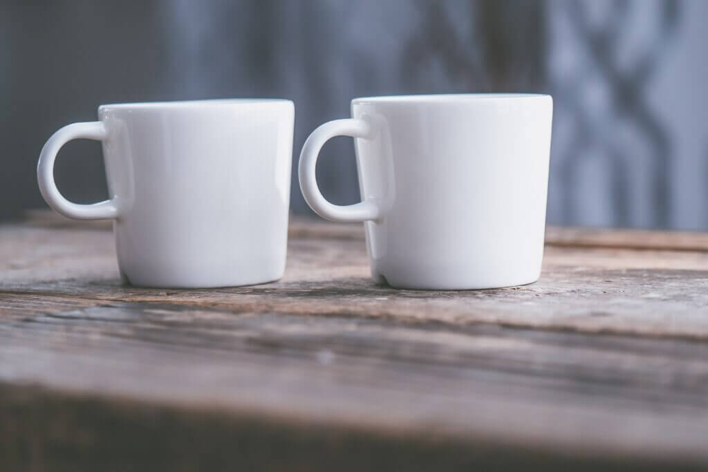 2 weiße große Kaffeetassen stehen nebeneinander