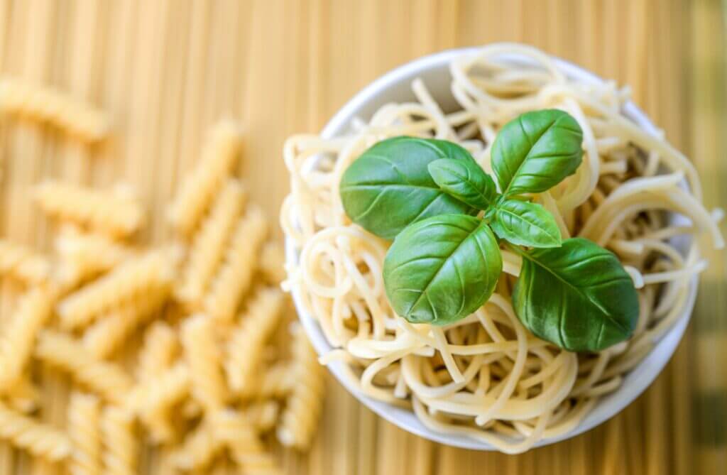 Eine Schale mit Spaghettis und einem Basilikum-Blatt.