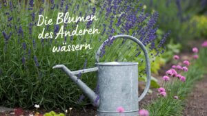 Blumenbeet wird mit Gießkanne gegossen