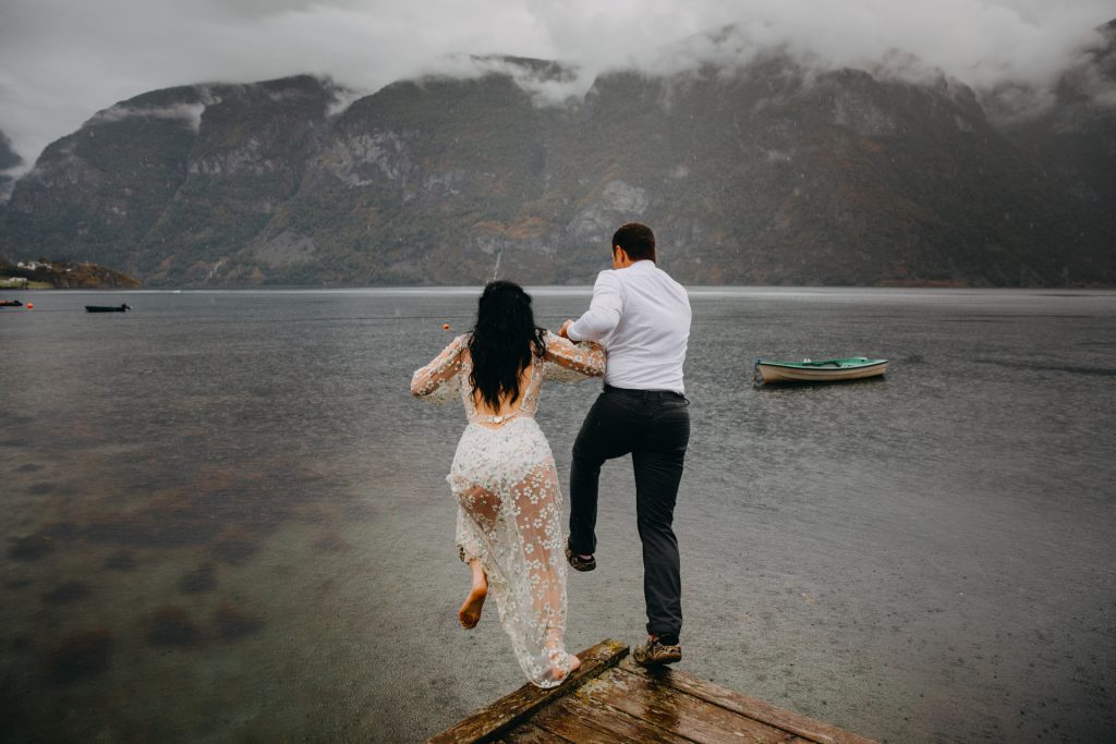 Bride and groom taking a leap into the water during their elopement wedding day in Aurland Norway - photo by Christin Eide Photography