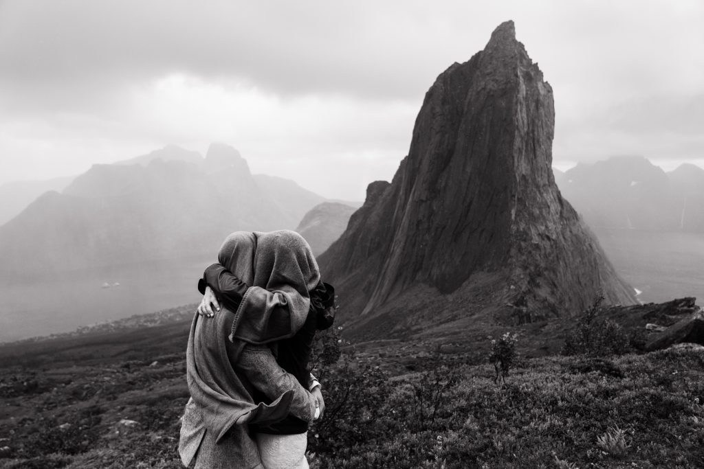 Keeping each other safe during storm, elopement Senja, Norway. By Christin Eide Photography