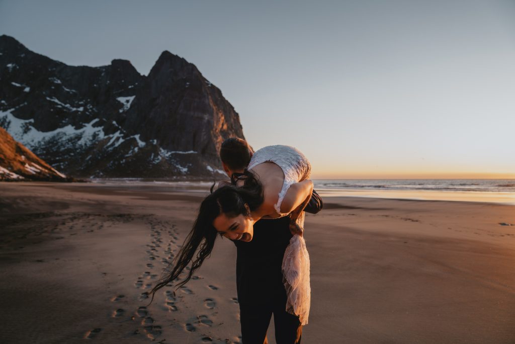 Beach elopement carrying your bride in Lofoten Norway. By Christin Eide Photography