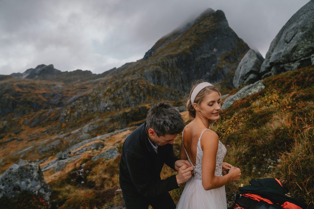 Bride on a mountain hike elopement getting ready. Lofoten, Norway. By Christin Eide Photography