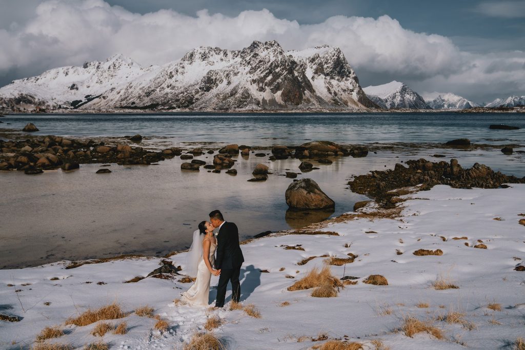 Winter elopement in Lofoten. Snow walk kissing. By Christin Eide