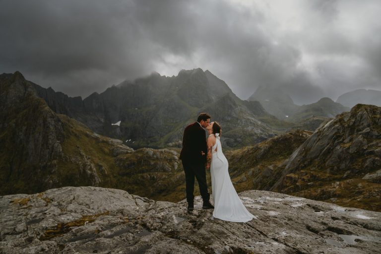 Kiss on a mountaintop in Lofoten, Norway by Christin Eide Photography