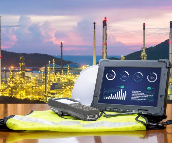 Smart factory - Rugged computers tablet in front of oil refinery industry.