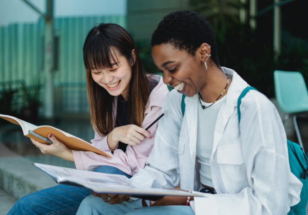 Multi-ethnic students smiling while doing their homework