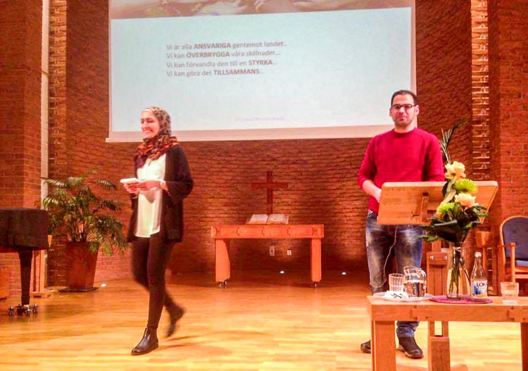 A woman and a man presenting on stage