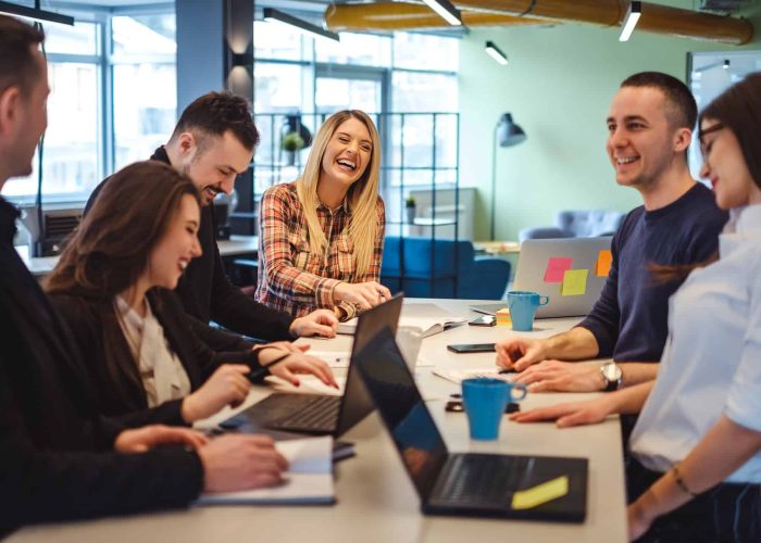 Happy colleagues laughing in the office meeting Happy colleagues laughing in the office at the meeting table