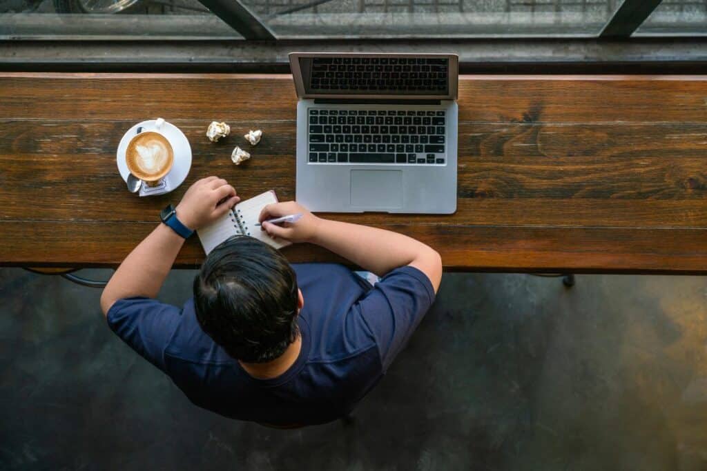 Man vid laptop på café
