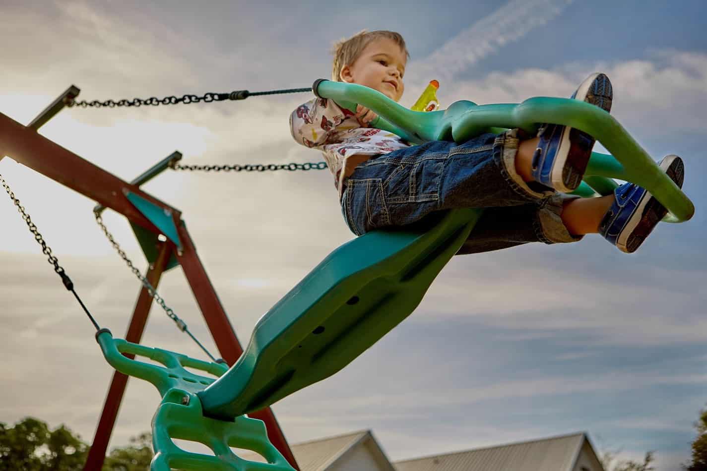 Playground with boy on swings