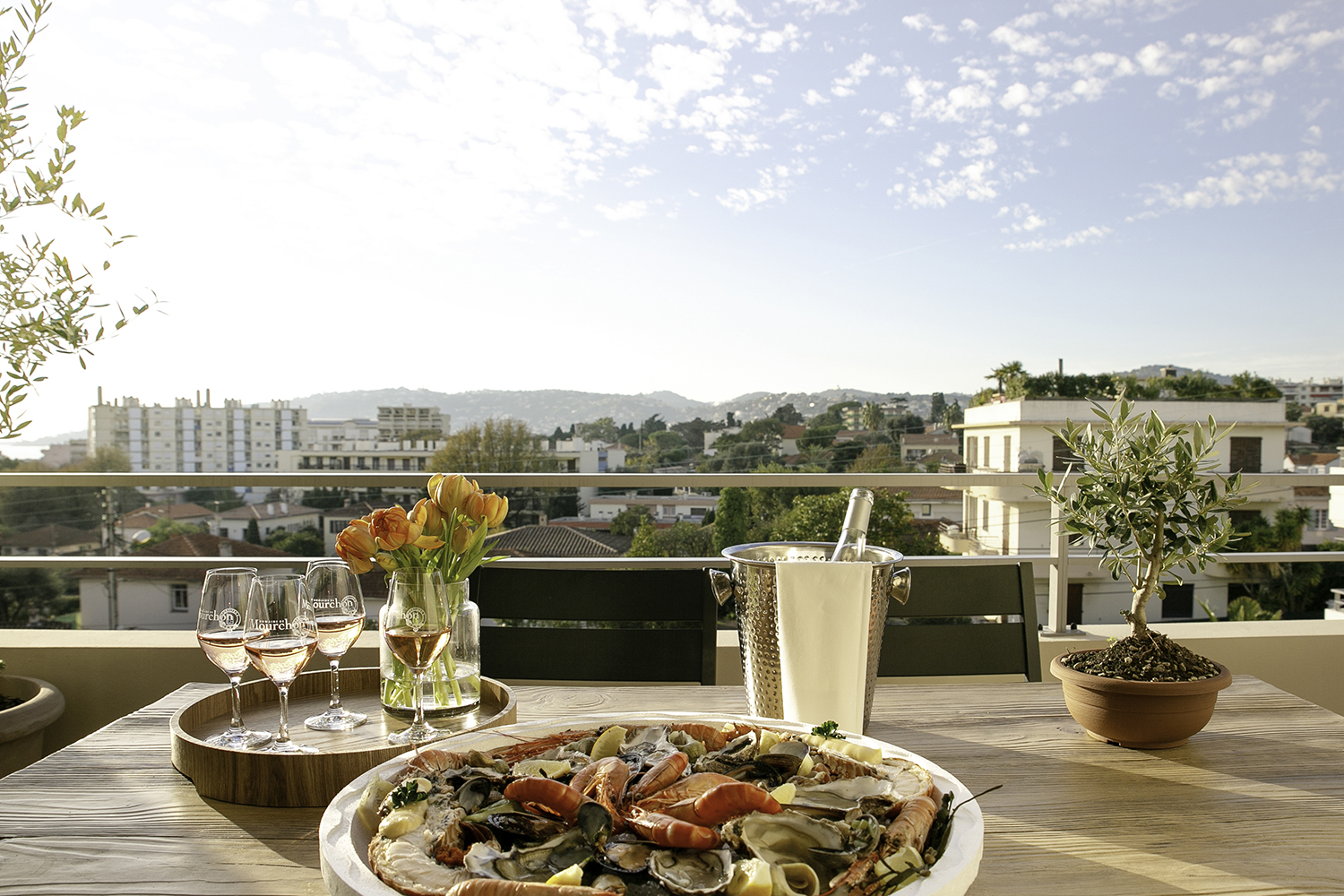 Terrasse med snacks og vin mot blå himmel