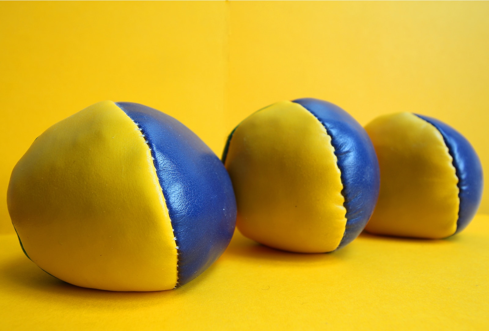 three blue and yellow balls on a yellow background