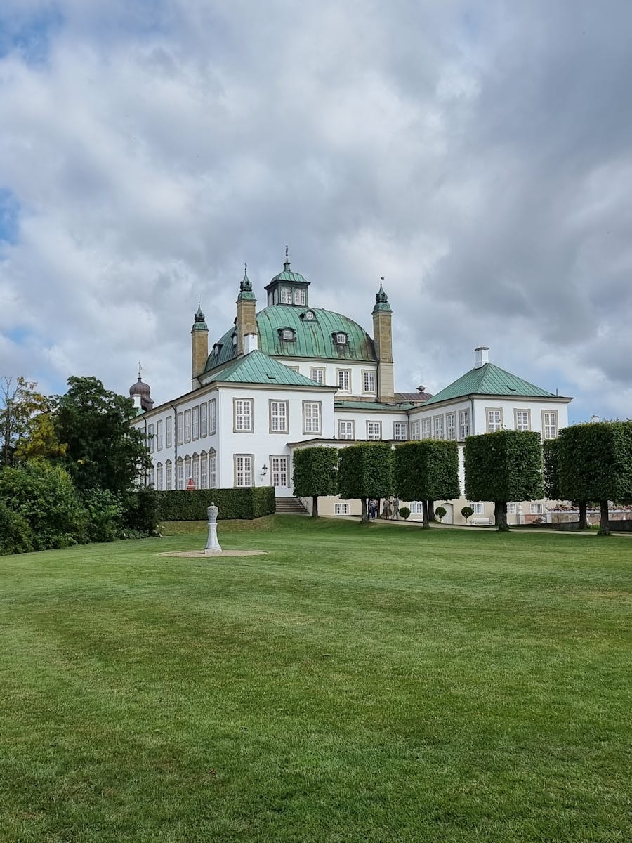 A Fredensborg Palace Near the Green Grass Field Under the White Clouds