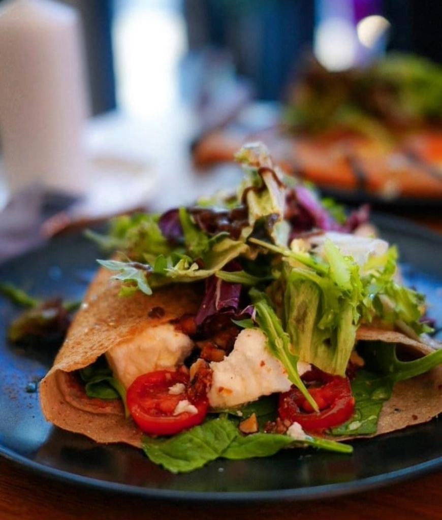 Spinatcrêpe med mozzarella, ferske spinatblader, cherrytomater og soltørkede tomater, servert med ruccola og balsamico. Glutenfri alternativ.