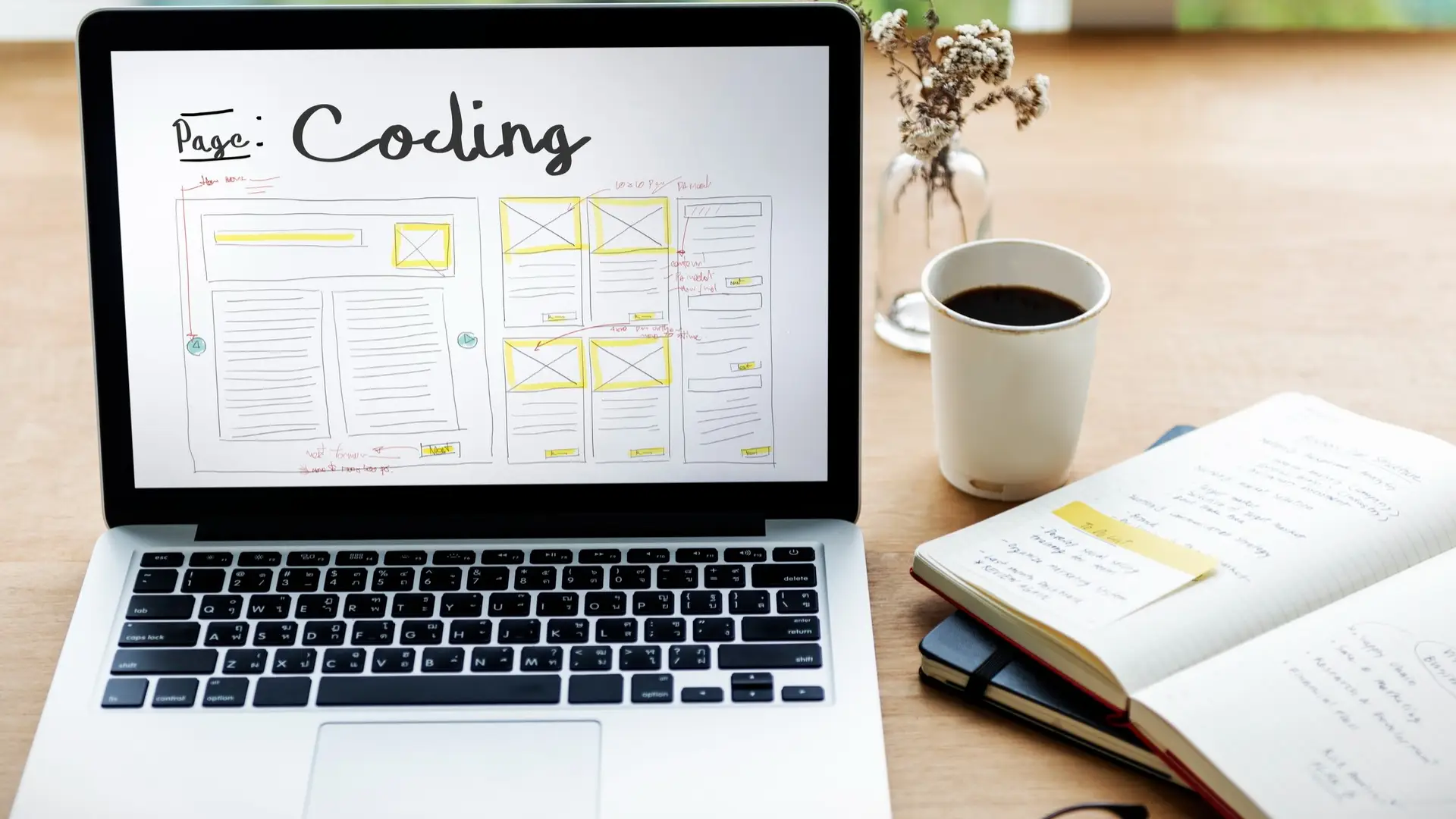 Kreativ arbetsyta med laptop som visar wireframe och anteckningsbok med innehållsidéer – symboliserar rubrikskrivning och innehållsplanering.