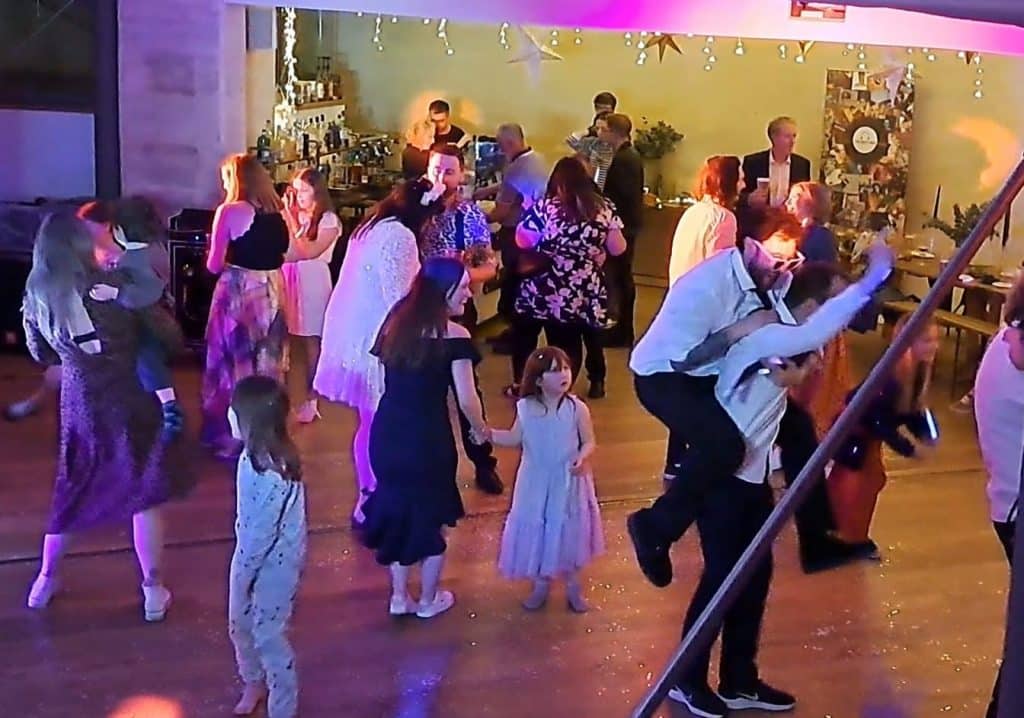 A happy dancefloor at the ska punk wedding, with one man giving another a piggyback