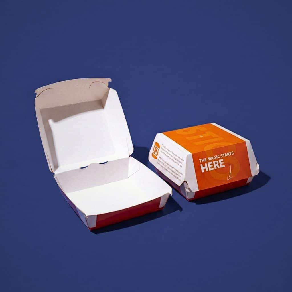 Custom printed cardboard burger packaging with orange branding. Display showing both open and closed views of disposable takeout food containers.