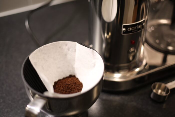 Filterkorg med malt kaffe i, redo att sättas in i Aarke Coffee Maker