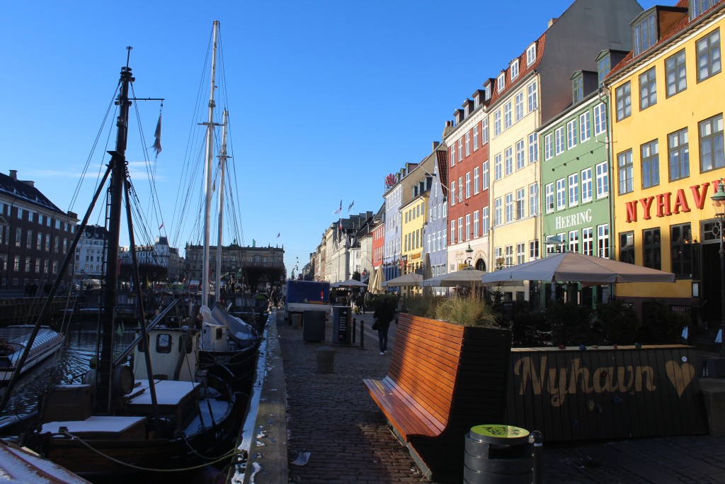 Nyhavn sunny side. View to safety concrete barrier covered with a batch, flowers and a climbing wall for children.