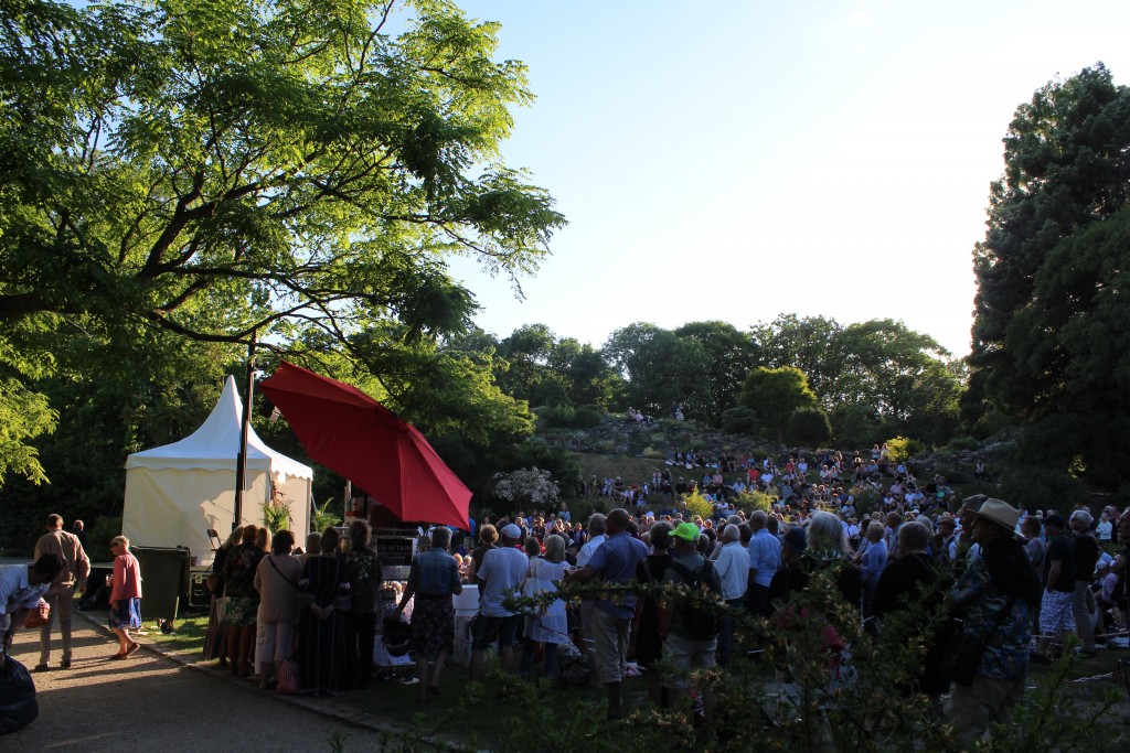 Udsigt mod scene 11 og publikum foran scenen og på skråningen op til Stenhøjen med alpeplanter. Foto den 5. juni 2018 kl 19.30-50 af Erik K Abrahamsen.